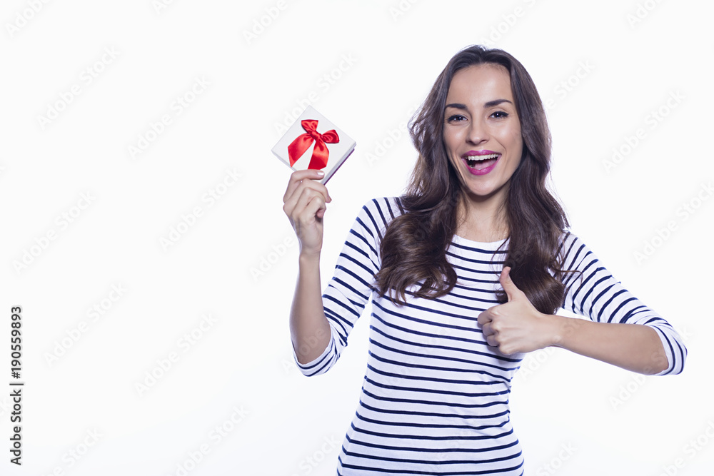 Beautiful young smiling woman in casual clothes holding a gift Beautiful young smiling woman in casual clothes holding a gift