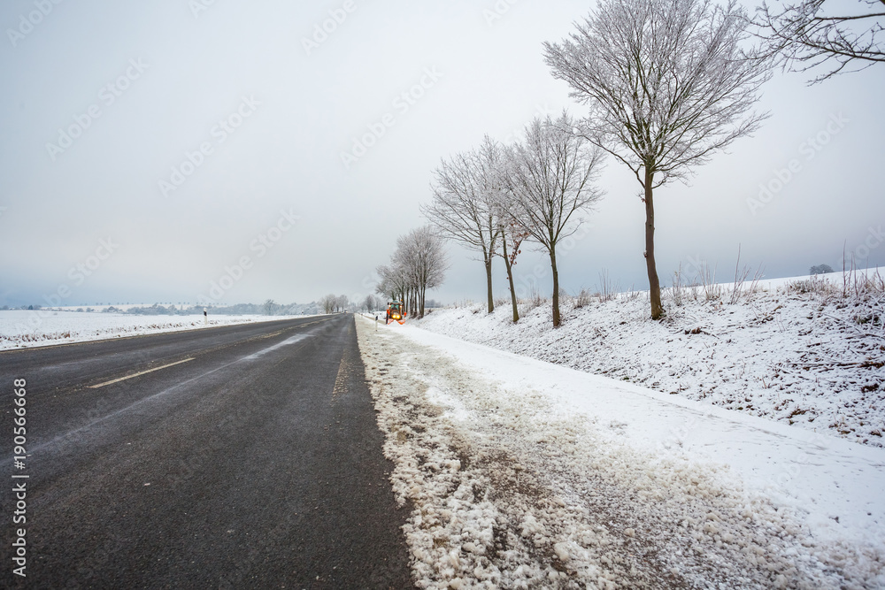 tractor cleans the bicycle road from snow, winter landscape tractor cleans the bicycle road from snow, winter landscape