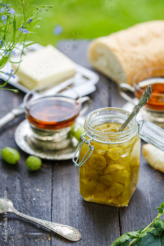 Green gooseberry jam on a wooden table photo