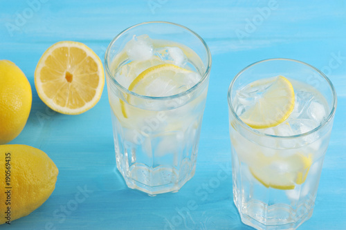 homemade lemonade - lemon, ice and water in glasses