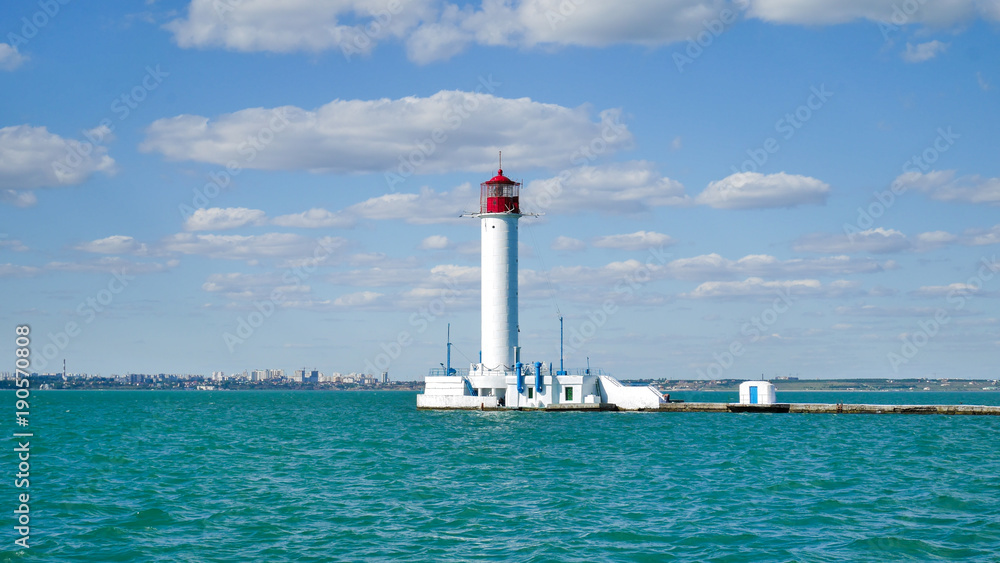 Odessa red and white lighthouse in bright sunny summer day in the middle of the Black Sea. Blue sky and calm water, horizontal orientation Odessa red and white lighthouse in bright sunny summer day in the middle of the Black Sea. Blue sky and calm water, horizontal orientation
