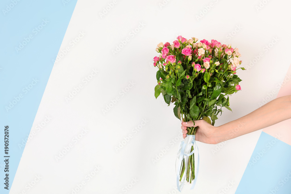 Naklejka premium Woman with beautiful bouquet of roses on color background
