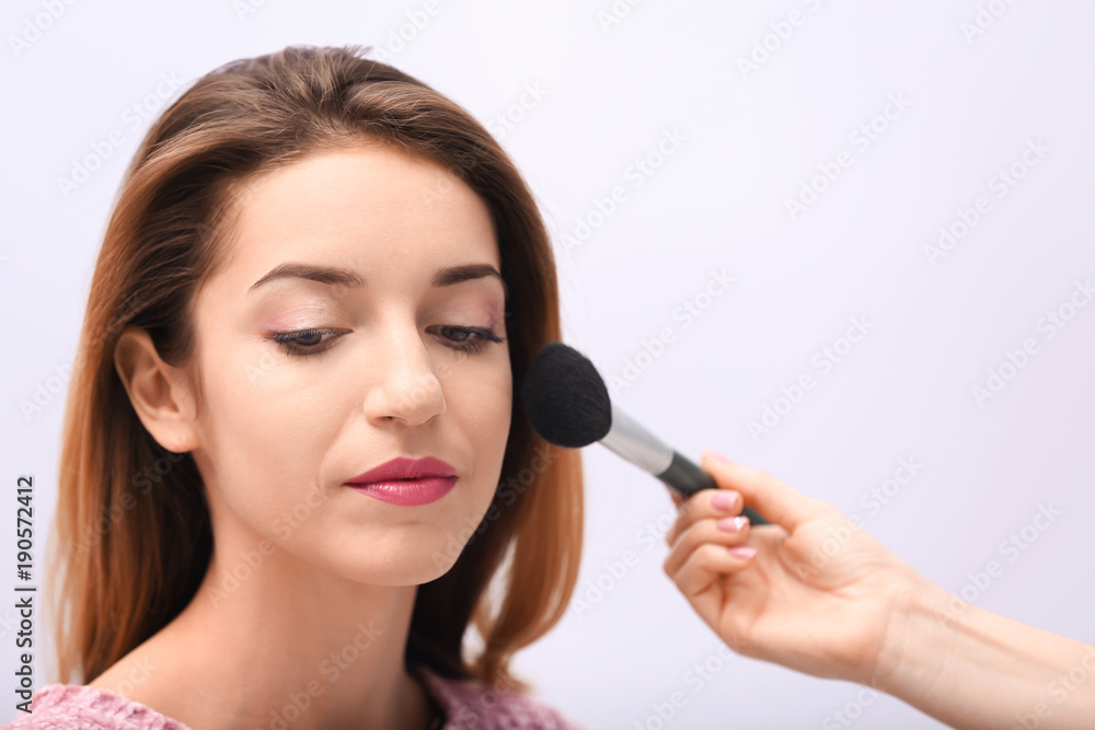 Makeup artist working with beautiful model, closeup Makeup artist working with beautiful model, closeup