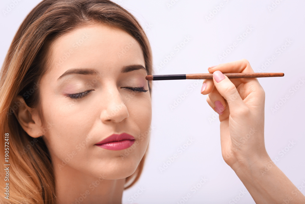 Makeup artist working with beautiful model, closeup Makeup artist working with beautiful model, closeup