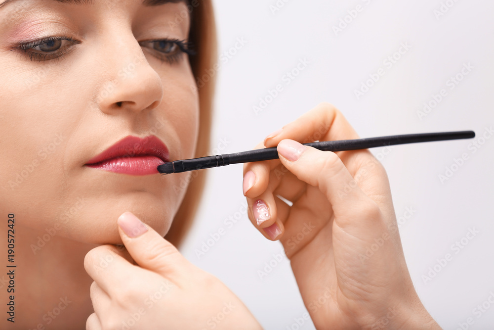 Makeup artist working with beautiful model, closeup Makeup artist working with beautiful model, closeup