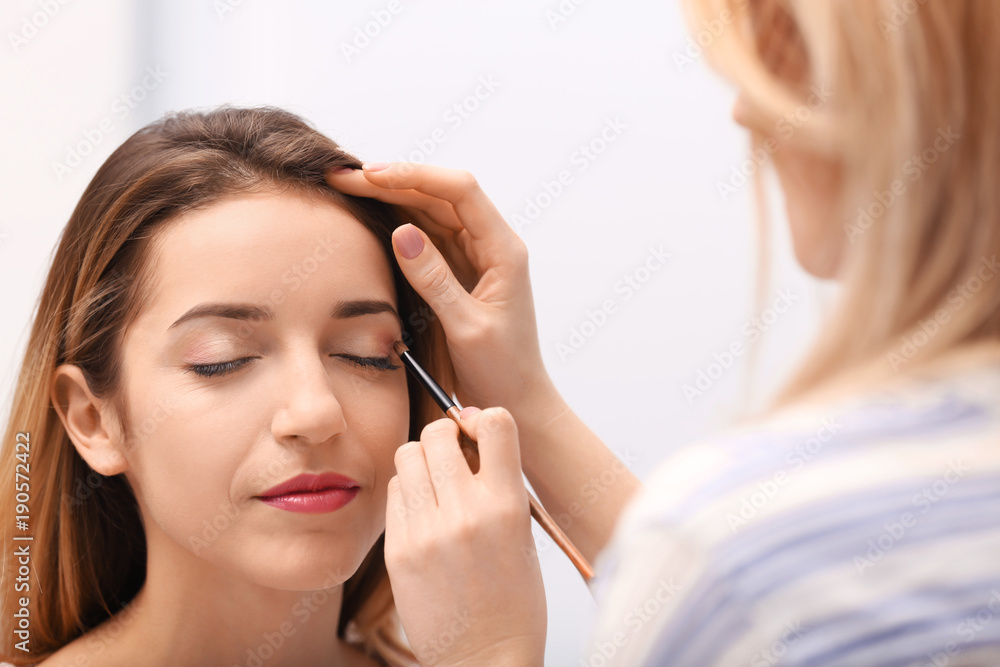 Makeup artist working with beautiful model, closeup Makeup artist working with beautiful model, closeup