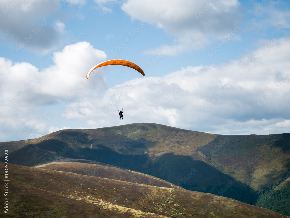 Stunning mountain landscape with Paraglider. The mountain range in the Carpathians. View from the mountain Gemba, (Pylypets, Zakarpatska oblast, Ukraine) Stunning mountain landscape with Paraglider. The mountain range in the Carpathians. View from the mountain Gemba, (Pylypets, Zakarpatska oblast, Ukraine)