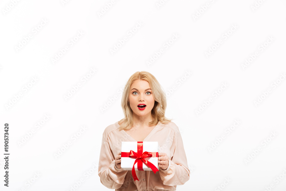 Shocked young woman holding gift box present Shocked young woman holding gift box present