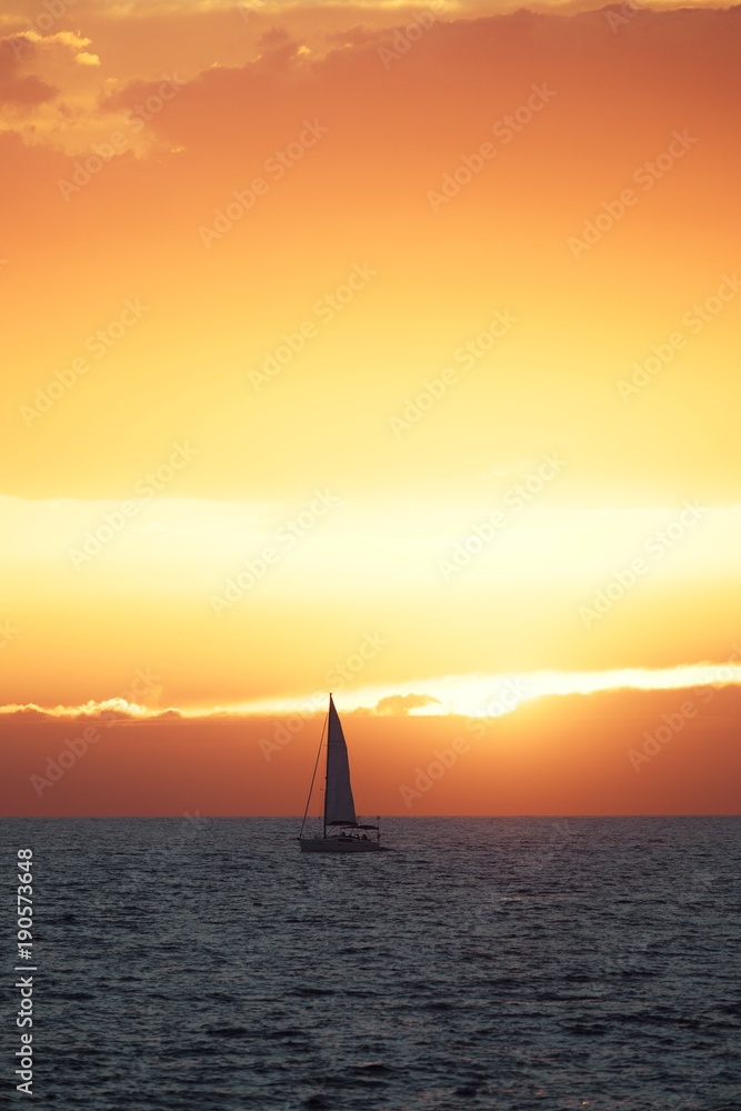 Beautiful sunset at the sea with sailing boat