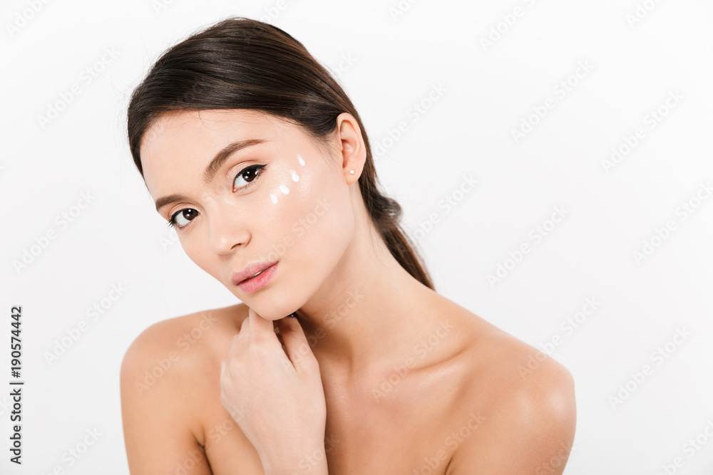 Beauty portrait of gentle asian woman looking on camera with cream on her face, isolated over white background Beauty portrait of gentle asian woman looking on camera with cream on her face, isolated over white background