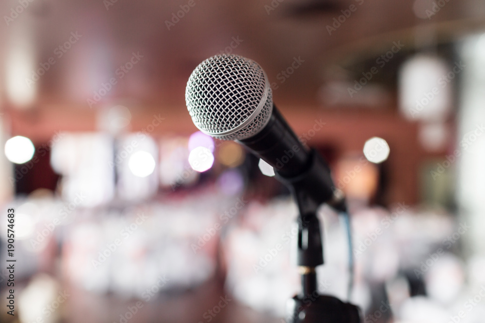 Microphone close-up. Focus on mic. Abstract blurred conference hall or wedding banquet on background. Event concept Microphone close-up. Focus on mic. Abstract blurred conference hall or wedding banquet on background. Event concept