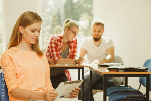 Student girl with tablet in front of her classmates