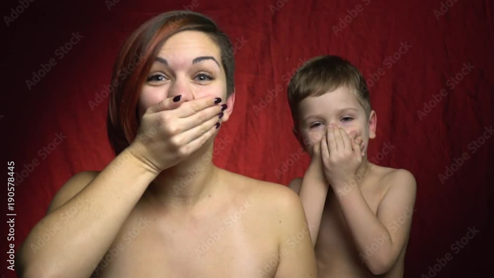 Woman and her child close their mouths with surprise Woman and her child close their mouths with surprise