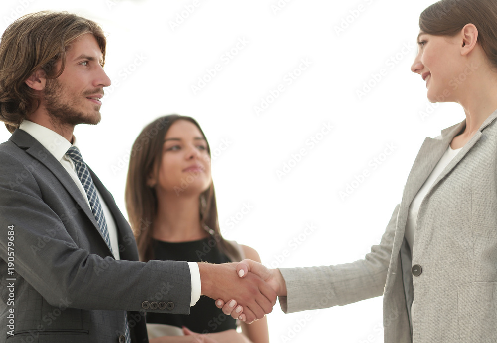 Businesspeople shaking hands against room with large window loo Businesspeople shaking hands against room with large window loo