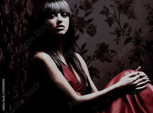 Beautiful woman seated in dark room. photo