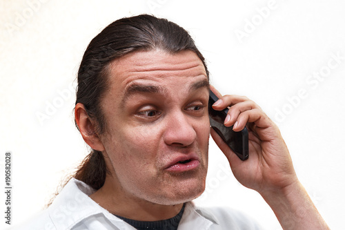 Man with funny face talking on the smartphone