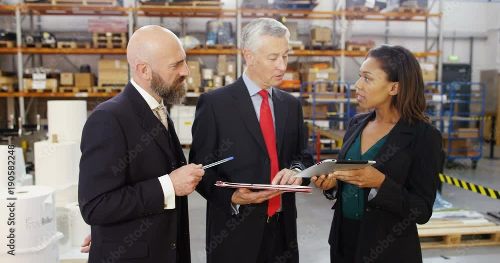 4k, Three warehouse workers discussing logistics of their business in a warehouse. 4k, Three warehouse workers discussing logistics of their business in a warehouse.
