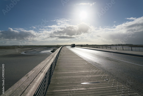 Normandie France-January 26  2018  People walk on the bridge and the sand beach near Mont-Saint-Michel at low tide.    