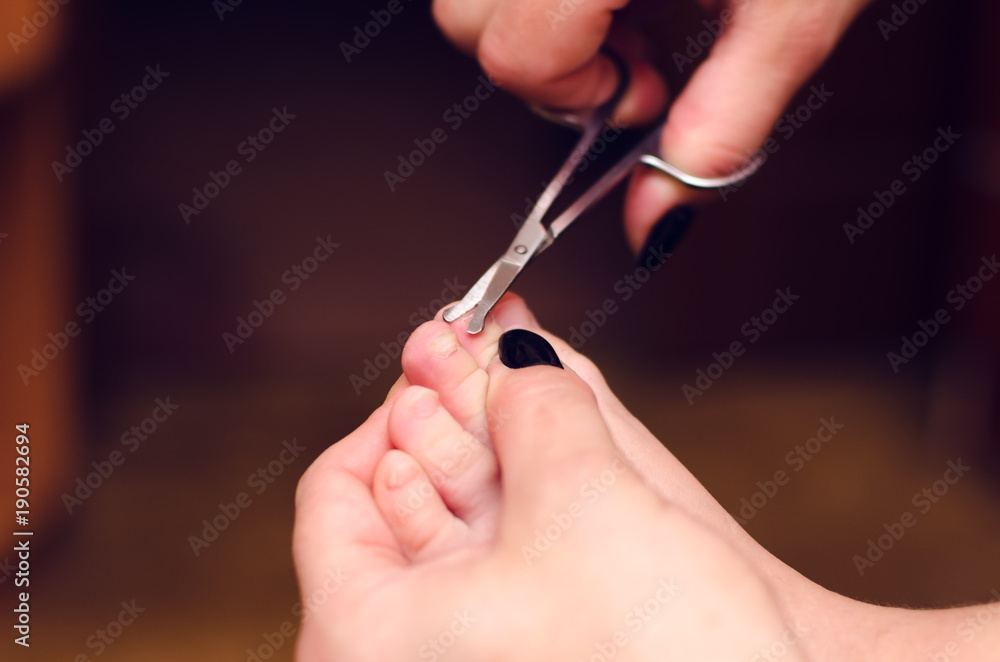 The mother cuts the child's nails on the legs close-up The mother cuts the child's nails on the legs close-up