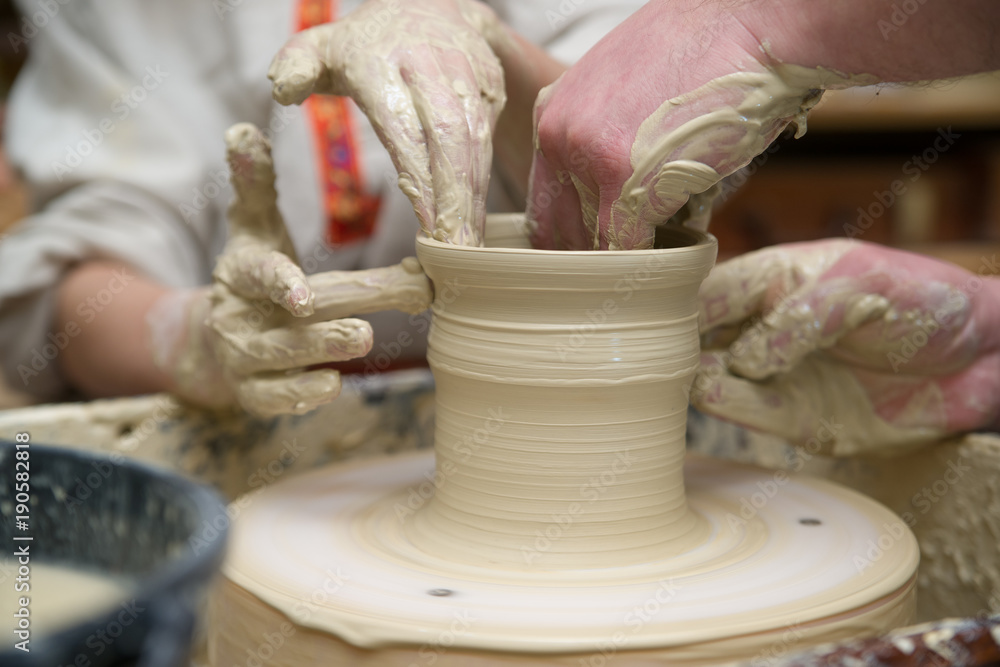 Hands of young potter kneading clay