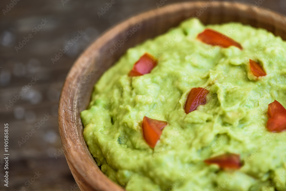 Guacamole in the Bowl on Wooden Table Guacamole in the Bowl on Wooden Table