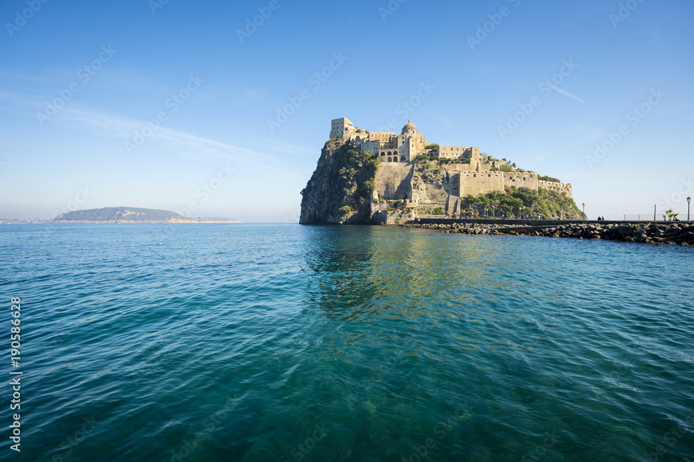 Scenic morning view of the dramatic Aragonese Castle looming from its ancient mountaintop perch above the Mediterranean island of Ischia, Italy