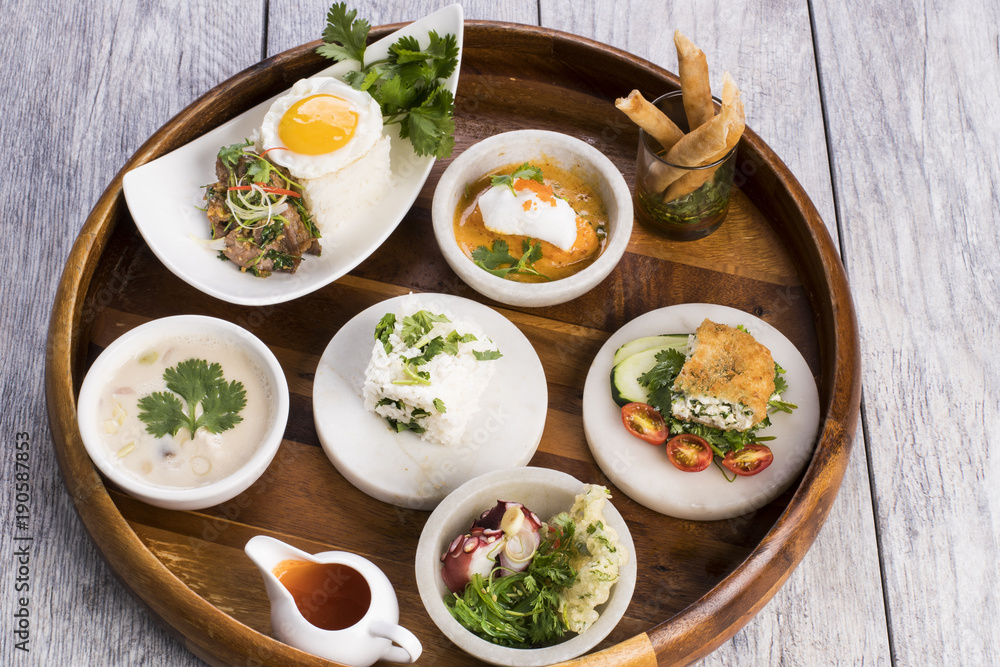 Assorted Thai food on wooden platter Assorted Thai food on wooden platter