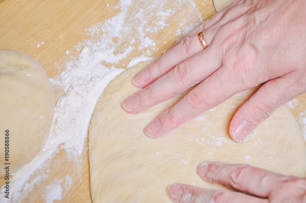 Woman doing manually the flat cake of leavened wheat dough Woman doing manually the flat cake of leavened wheat dough