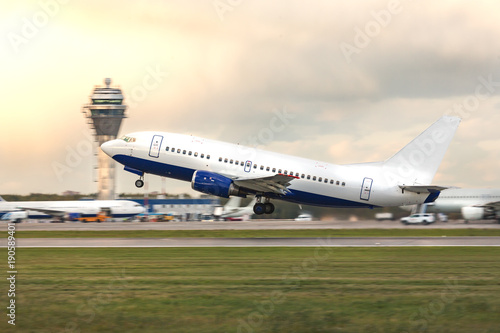 Obraz na plátně Airplane in takeoff mode, side view/ Aircraft flies against the backdrop of air