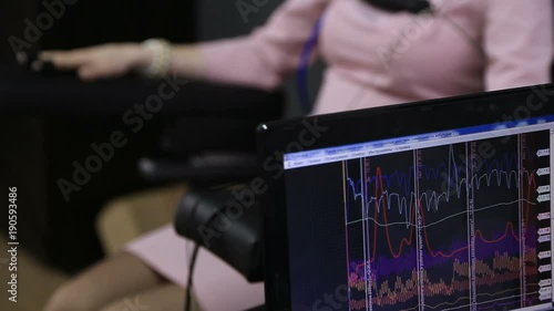 Lie-detector test, a woman answers the questions of the expert A woman answers the questions of the expert polygraph sitting on a chair in an office photo
