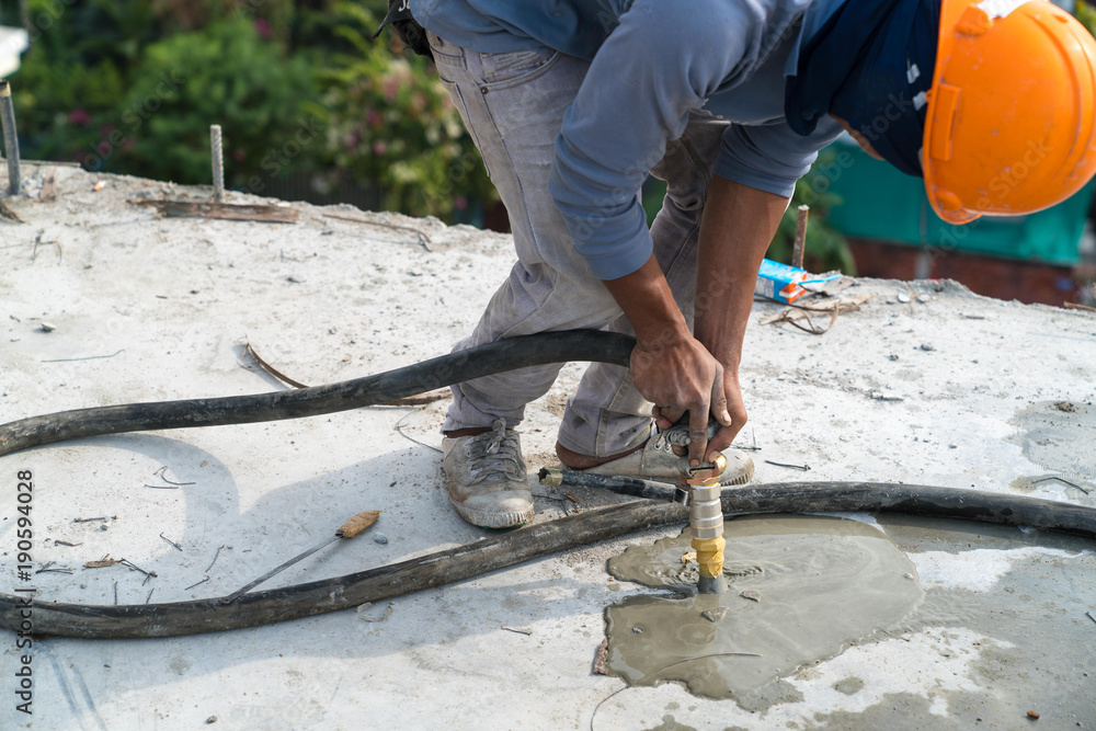 Civil worker grout cement in tube of sling steel in post tension slab system in construction