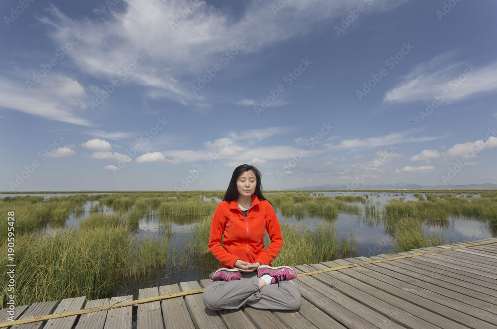 A young woman is sitting in meditation