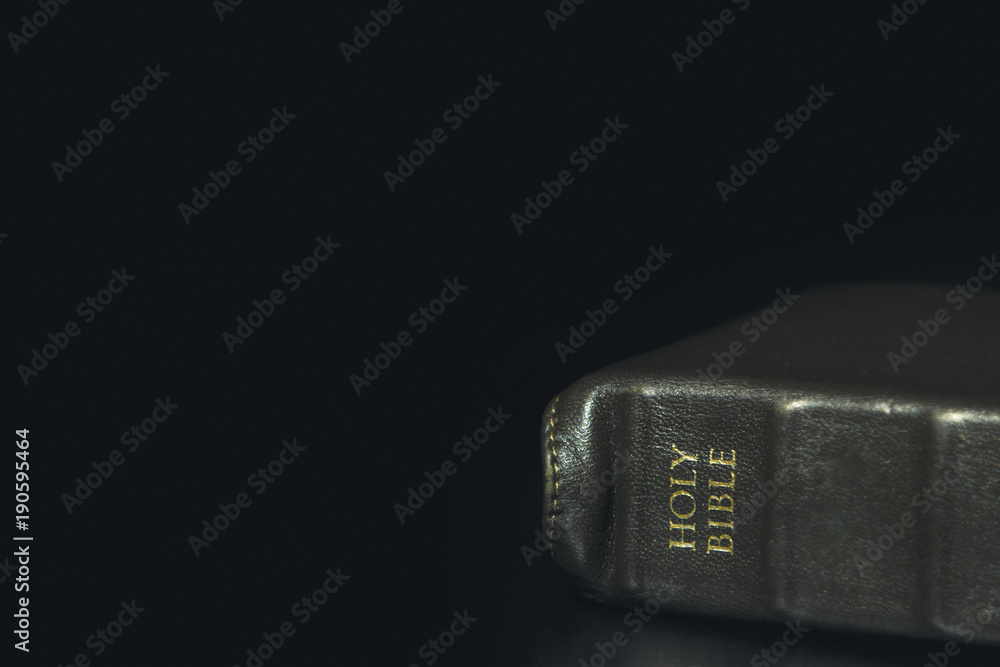 Simple Leather Bound Holy Bible on a Black Table with Copy Space Simple Leather Bound Holy Bible on a Black Table with Copy Space