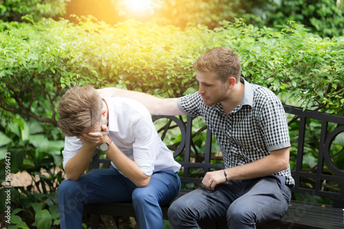 Business man Stressed and Frustrated in the garden and his friend soothe 