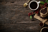 Top view mockup on wood background with a cup of coffee and red ripe coffee beans. Top view with copy space, flat lay.