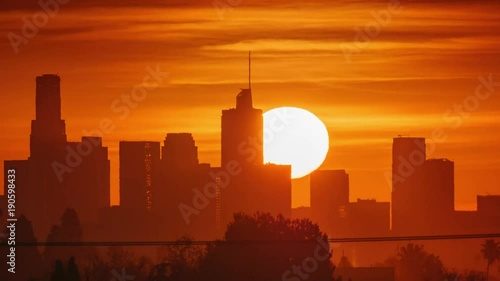Sunrise sun rising over downtown Los Angeles skyscrapers, zoom in on city skyline. 4K UHD timelapse.
