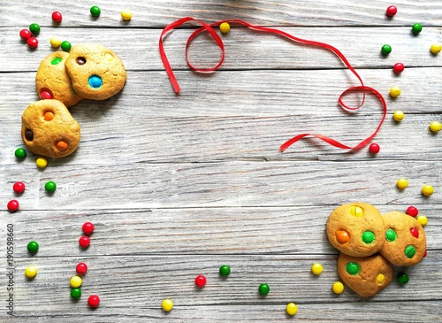 cookies made from cream cheese and colorful candies on a white wooden background with fading 