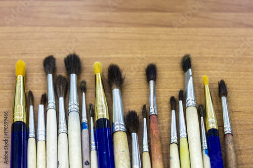 Artist brushes on a wooden table. Background.