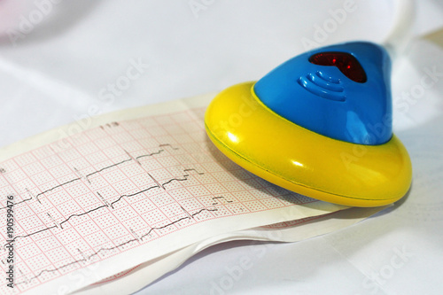 Close-up of a toy stethoscope on medical card and cardiogram photo