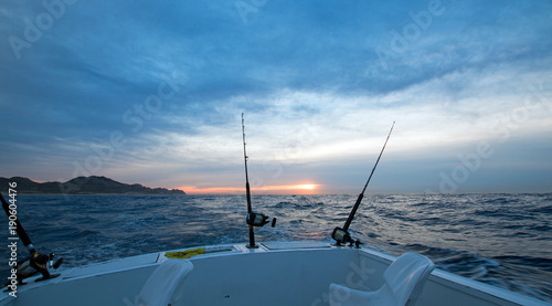 Φωτογραφία Sunrise view of two fishing rods on charter fishing boat on the Pacific side of