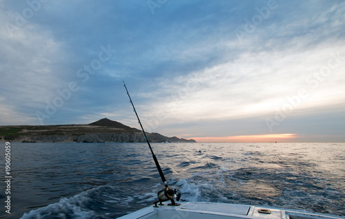 Sunrise view of fishing rod on charter fishing boat on the Pacific side of Cabo San Lucas in Baja California Mexico B C S