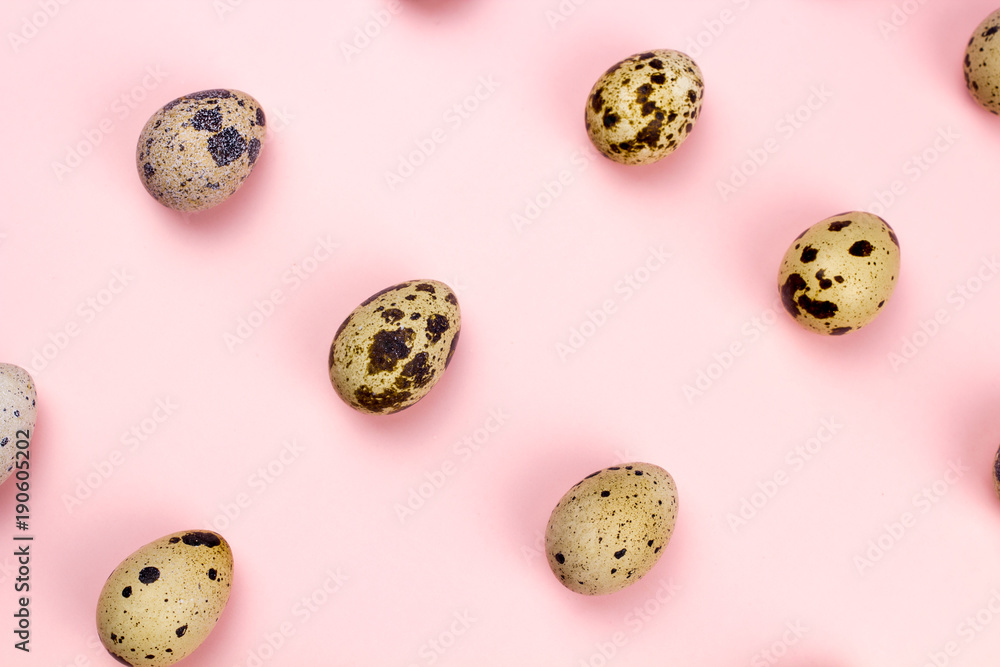 Holiday easter quail eggs on pastel pink background. Close up.