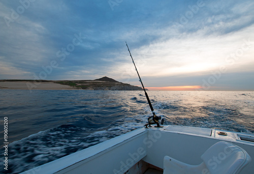 Sunrise view of fishing rod on charter fishing boat on the Pacific side of Cabo San Lucas in Baja California Mexico BCS