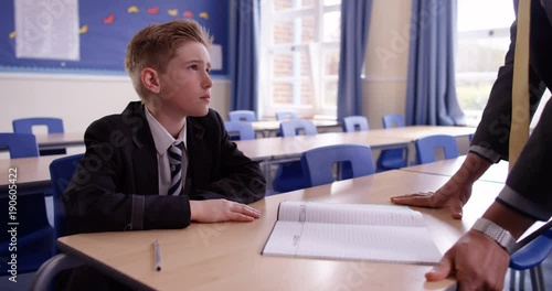 4K Naughty child kept after school for detention is given work to do by his teacher. Slow motion.