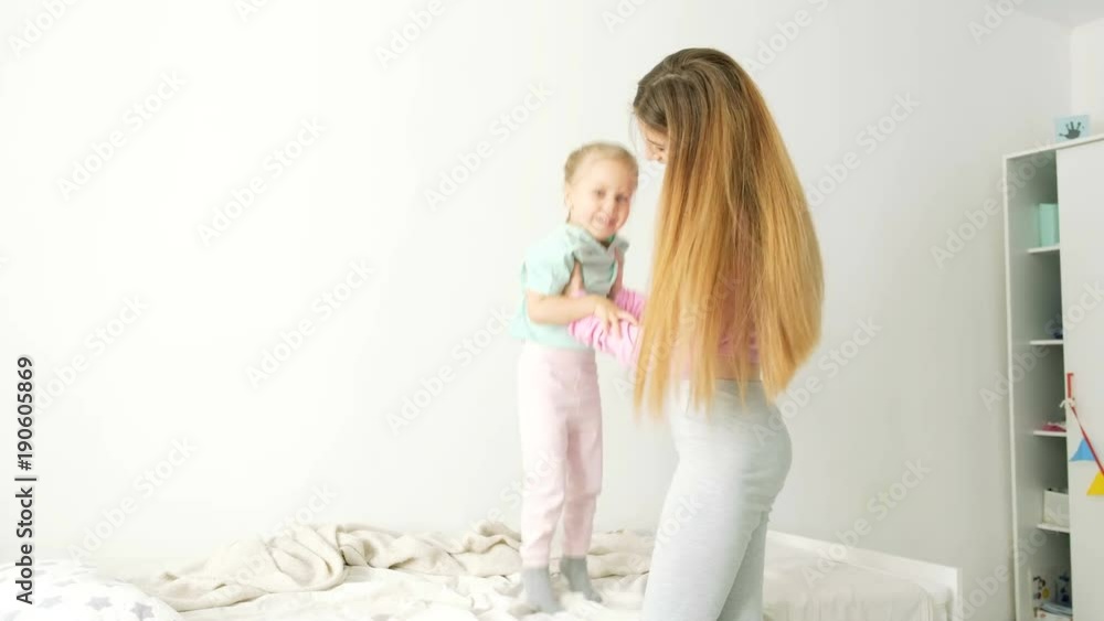 Happy young mother and daughter playing, drawing, playing games on your smartphone braid braids, read. Happy young mother and daughter playing, drawing, playing games on your smartphone braid braids, read.
