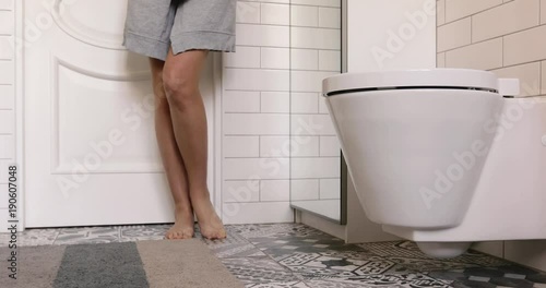 Woman with prostate problem in front of toilet bowl. Lady with hands holding People wants to pee - urinary incontinence concept
