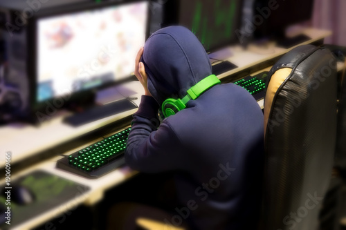 Tried gamer Sleeping in front of games monitor at internet cafe, game addiction concept, gamer lifestyle.
