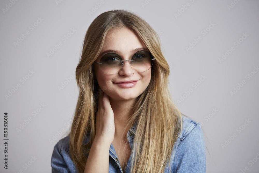 Fototapeta premium Smiling young woman in cool shades, portrait