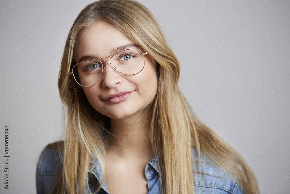 Glasses girl smiling to camera, studio