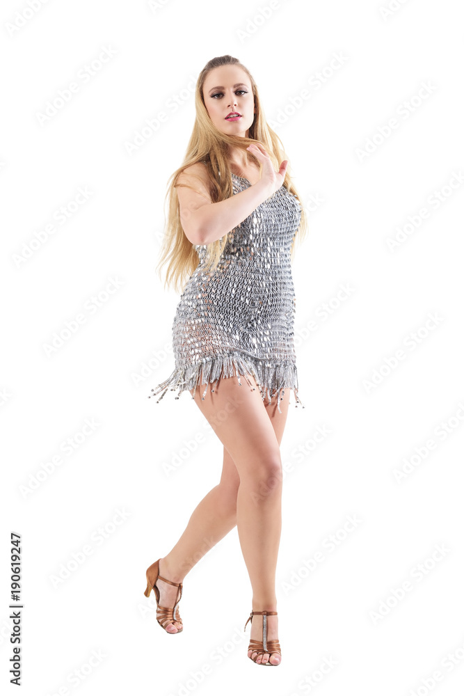 Naklejka premium Passionate attractive blonde woman disco dancing in glowing silver sequin dress. Full body length portrait isolated on white studio background. 